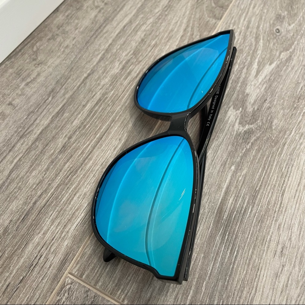 Sunglasses with a black frame and metallic blue shades